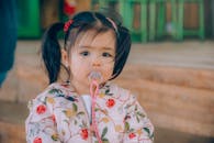 迷人的奶嘴，外面穿着花卉夹克，蹒跚学步