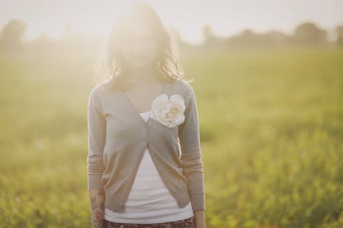 Woman in Gray Long Sleeve Shirt Standing on Field