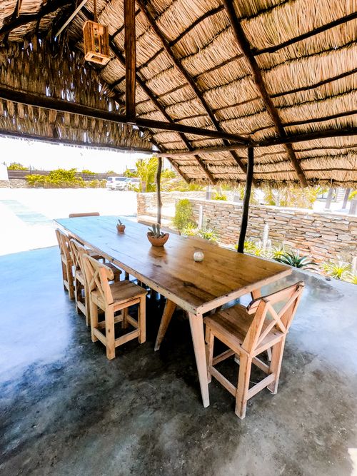 Free Wooden dining table and chairs under a thatched roof in Adicora, Venezuela. Stock Photo