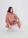 Woman in Pink Hoodie and Pants Sitting on White Floor