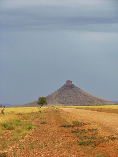 Free View of Mount Nameless in WA, Australia, with a dramatic sky and remote unpaved road. Stock Photo