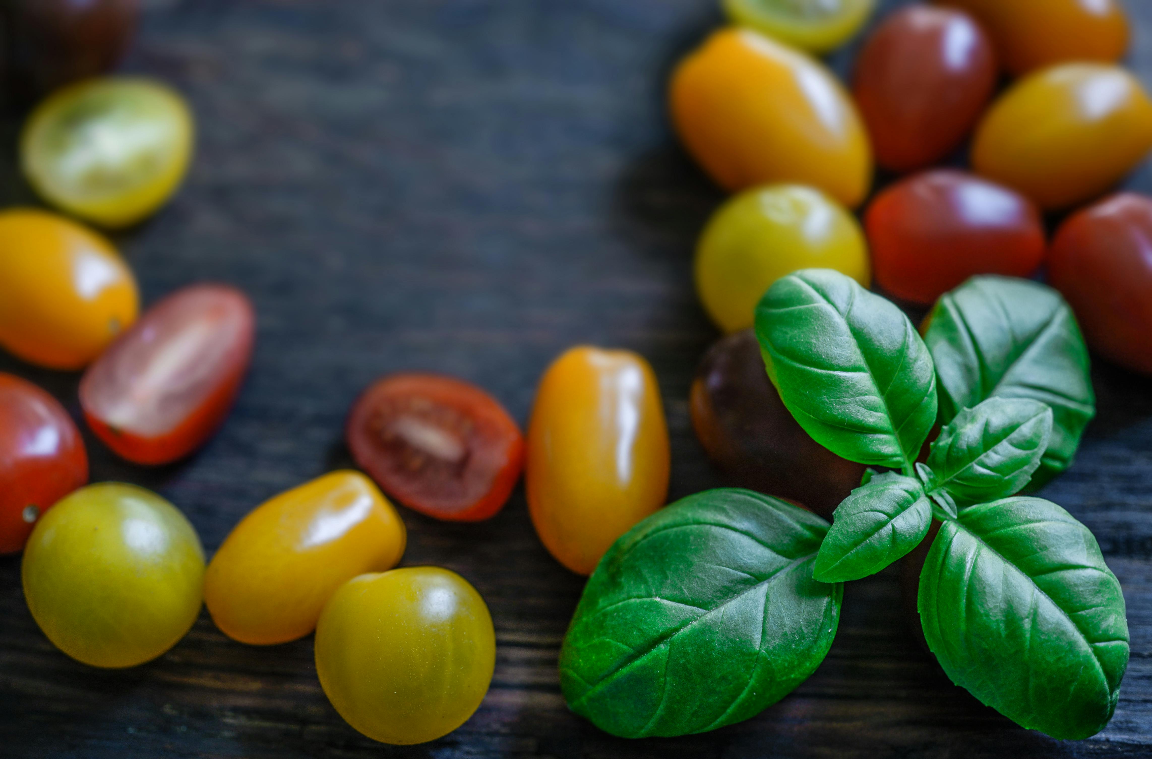 Fresh cherry tomatoes, basil leaves, and mozzarella balls on a wooden board - caprese appetizer skewers