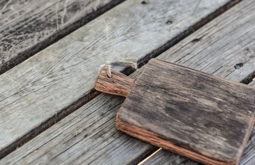 Free A rustic wooden cutting board on a vintage wood table, offering a natural aesthetic. Stock Photo