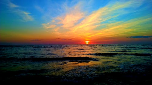 Body of Water Under Blue and Whit Sky