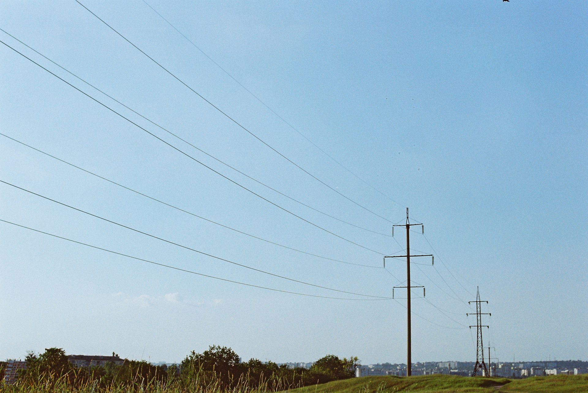 Transmission towers and power lines stretch against a clear blue sky, capturing industrial innovation.
