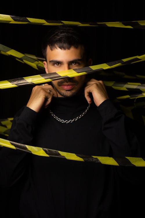 Man Standing in Black Long Sleeve Shirt with Silver Necklace