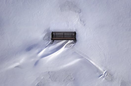 A serene aerial shot of an isolated bench surrounded by snow in Red Wing, Minnesota.