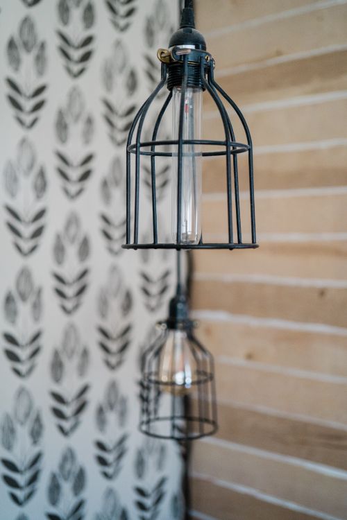 Free Industrial style hanging light bulbs with elegant wire cages, perfect for modern interiors. Stock Photo
