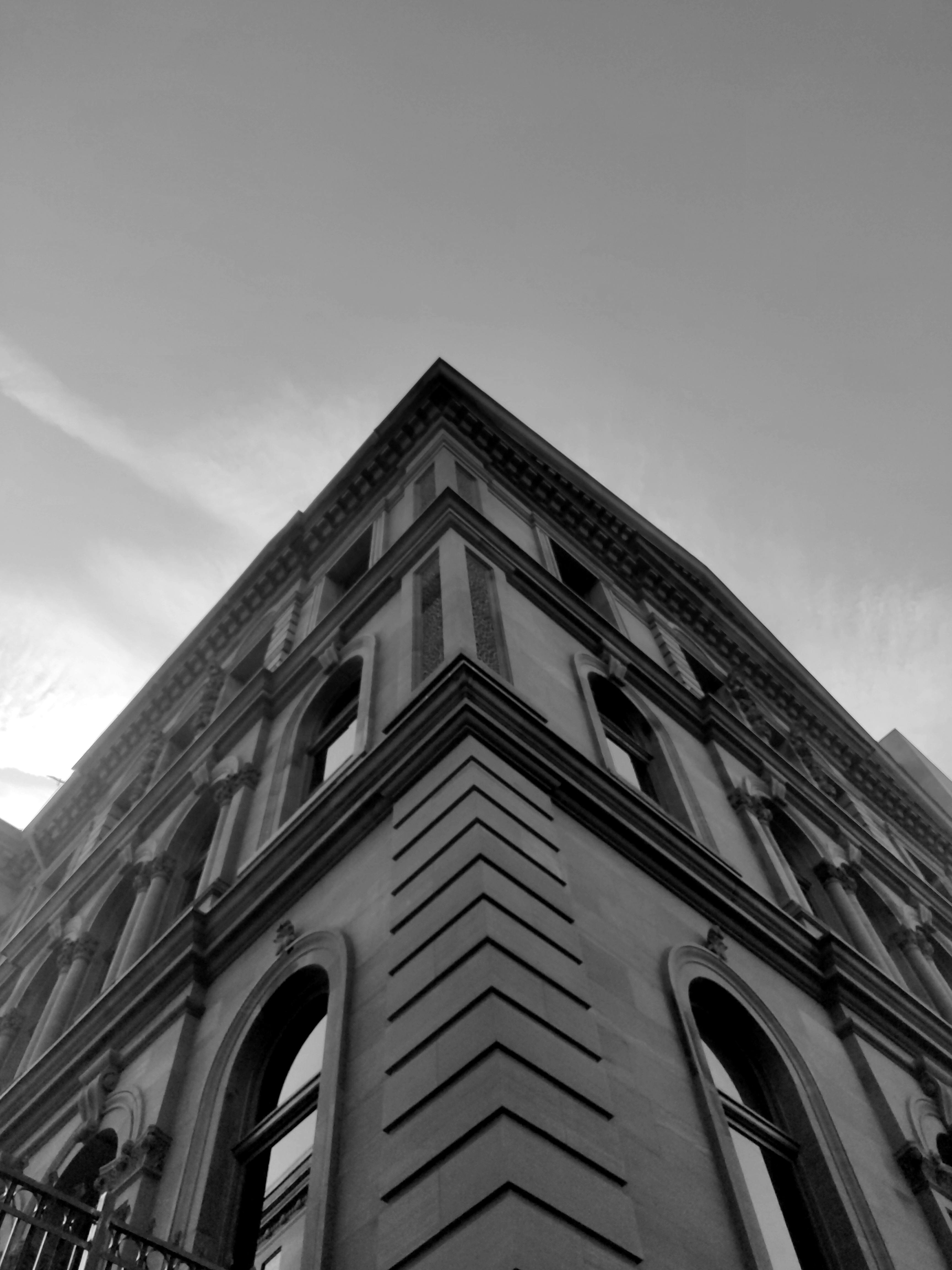 Free Striking black and white photo capturing a building from a low angle, highlighting architectural features. Stock Photo