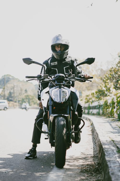 Free A motorcyclist in full gear riding a motorcycle on a sunny day road. Stock Photo