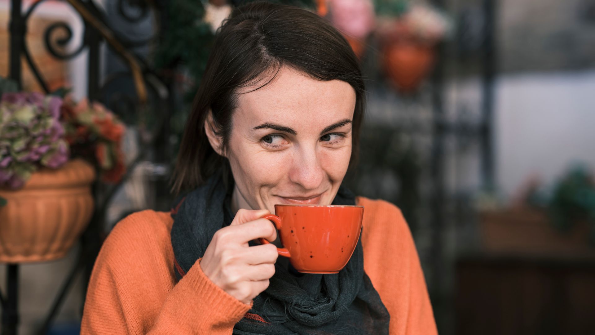 Modafinil and Coffee: The Ultimate Wake-Up Call Cheerful woman in orange sweater sipping coffee outdoors, exuding warmth and happiness — modafinil and coffee