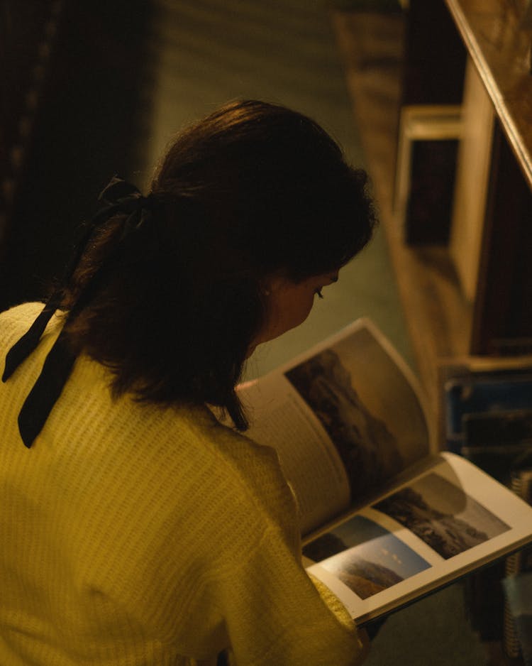 
A Woman Looking At Pictures In A Book