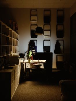 Warmly lit home office space featuring a desk and organized shelving.