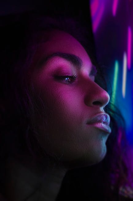 Close-up portrait of a woman with neon lighting, creating a dramatic and artistic effect.
