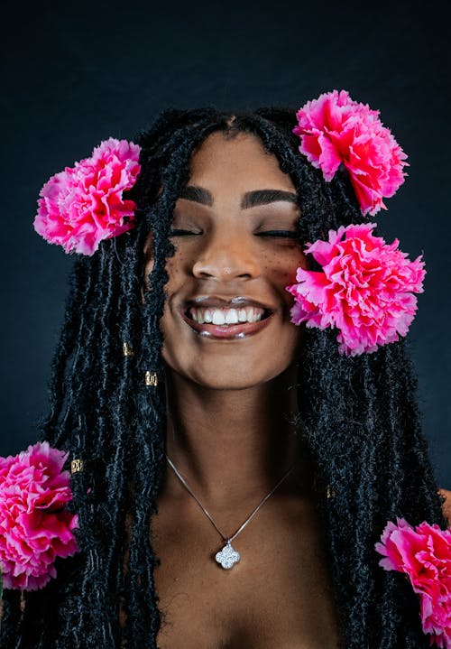 A Woman with Pink Flower on Her Dreadlocks