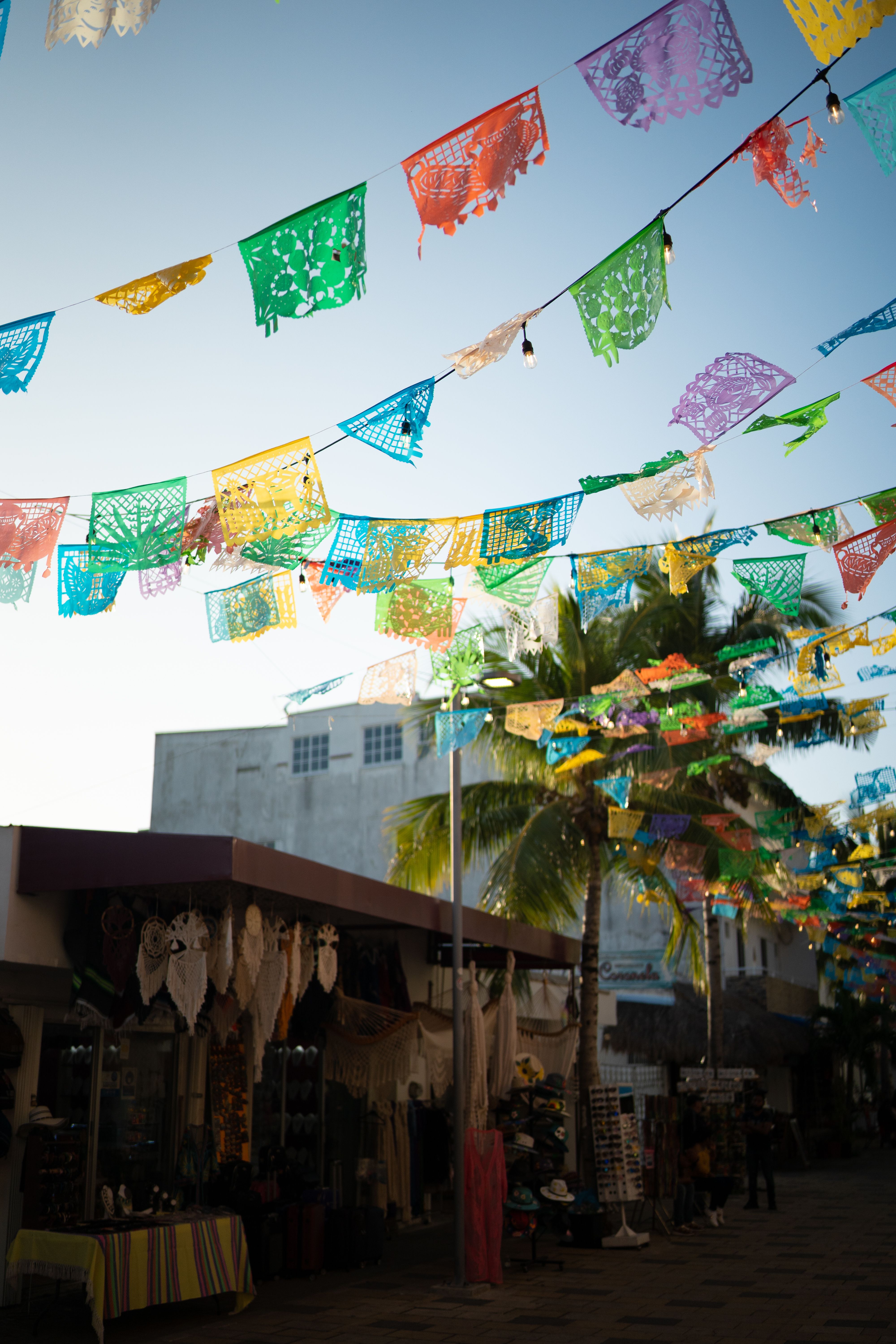 Rue mexicaine décorée de papel picado coloré tendu entre les façades