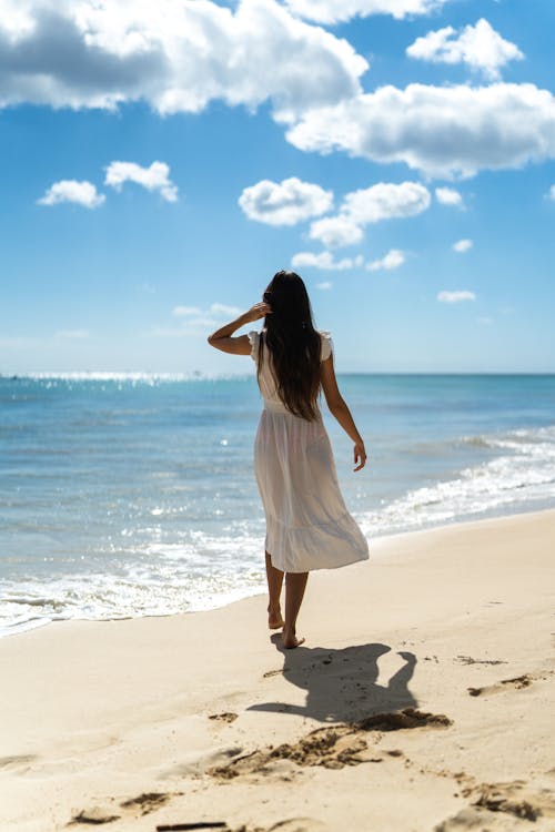 A Woman Wearing a White Dress at a Beach · Free Stock Photo