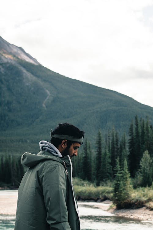 Man in Hoodie Jacket Standing Beside a Lake