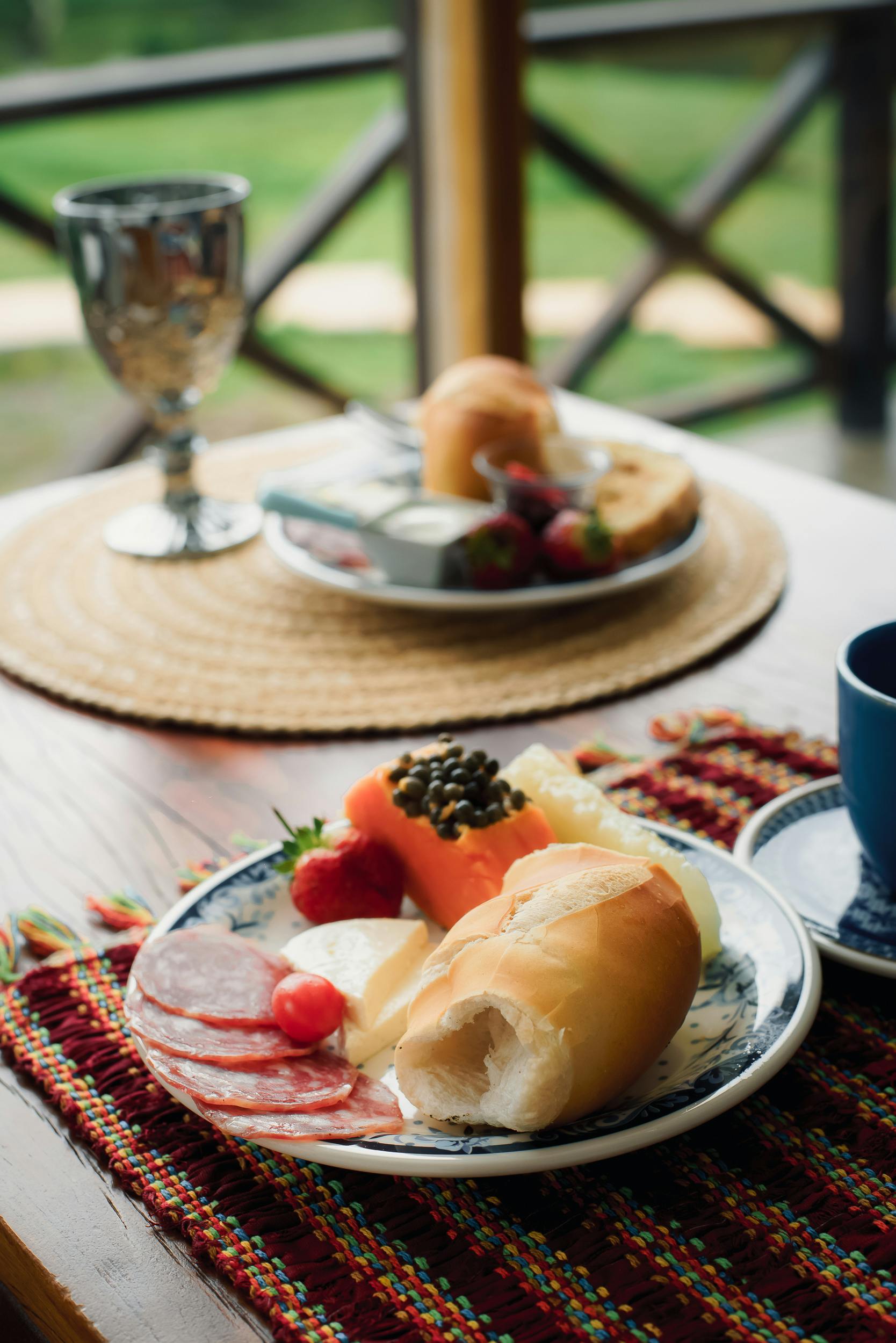 A visually appetizing Brazilian breakfast featuring fresh bread, cheese, and fruits on a rustic wooden table.