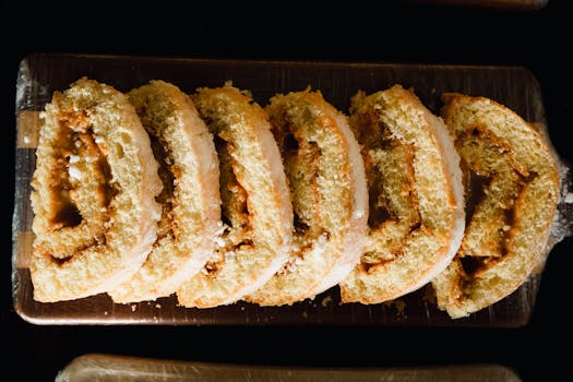 Close-up of sliced cake roll on a wooden tray, showcasing its texture and filling.