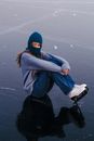 Woman with Ice Skates Sitting on Ice