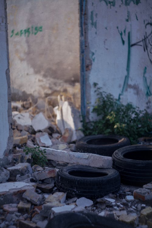 Broken Tires Beside a Damaged Wall