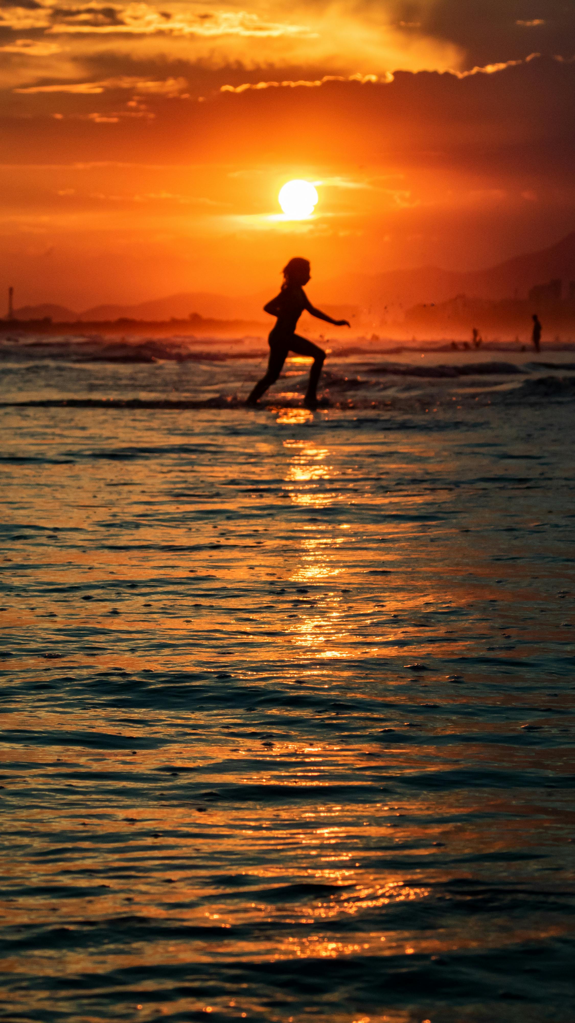 silhouette of a person running at the beach