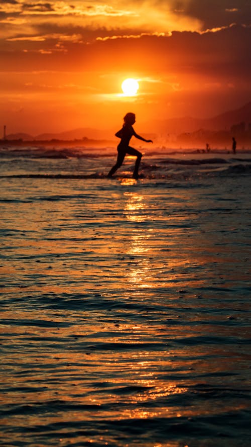 Silhouette of a Person Running at the Beach