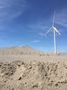 White Wind Turbine on Brown Sand Under Blue Sky
