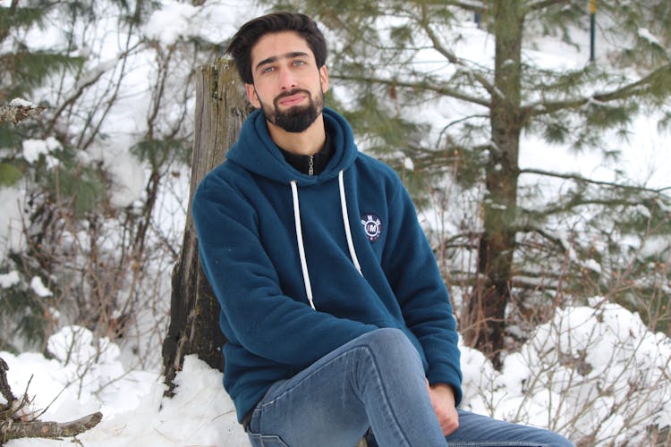 Man In Blue Hoodie Sitting On Snow