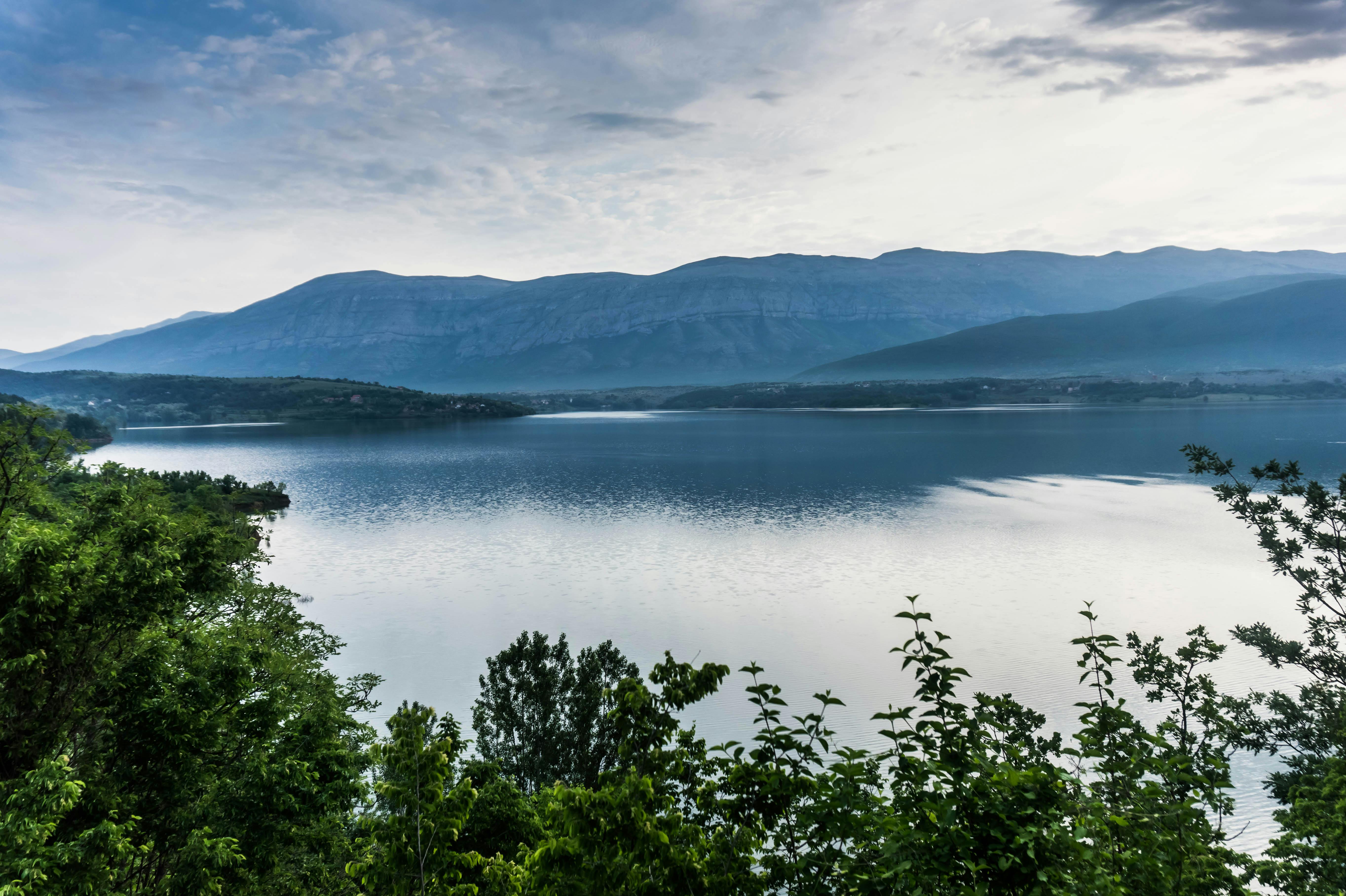 群山环绕、绿树葱茏的湖泊，呈现出一派和平景象
