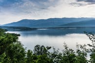 群山环绕、绿树葱茏的湖泊，呈现出一派和平景象