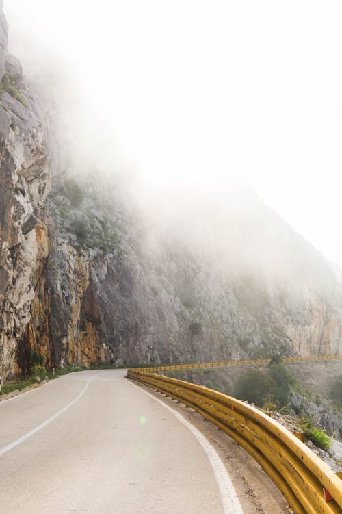 Photography of Road Near Foggy Mountain