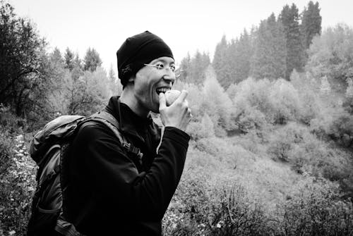 Grayscale Photograph of a Man Eating an Apple