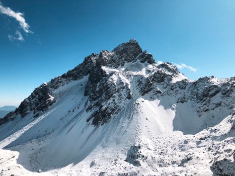 Stunning view of a snow-covered mountain peak in Lijiang, China under a clear blue sky.