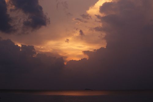 Free Stunning sunset with dramatic clouds over a calm sea, capturing nature's beauty. Stock Photo