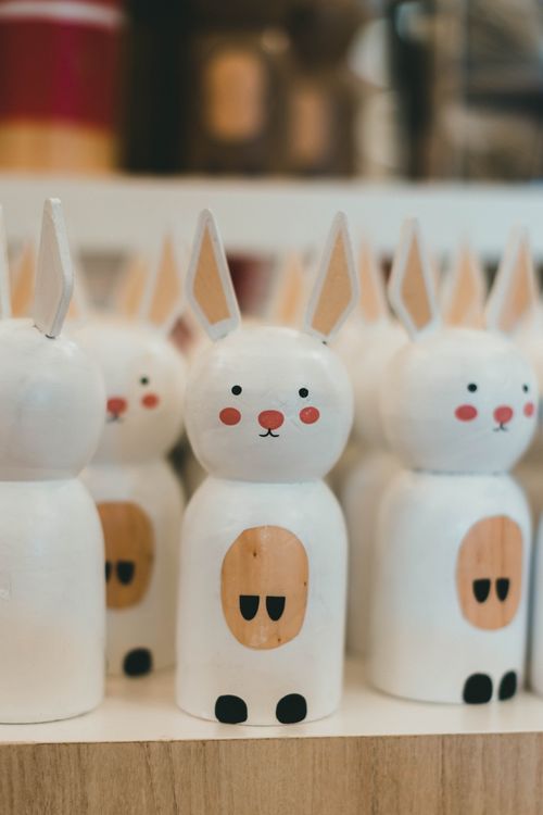 Free Charming handcrafted wooden bunny figurines lined up for sale, showcasing detailed craftsmanship. Stock Photo