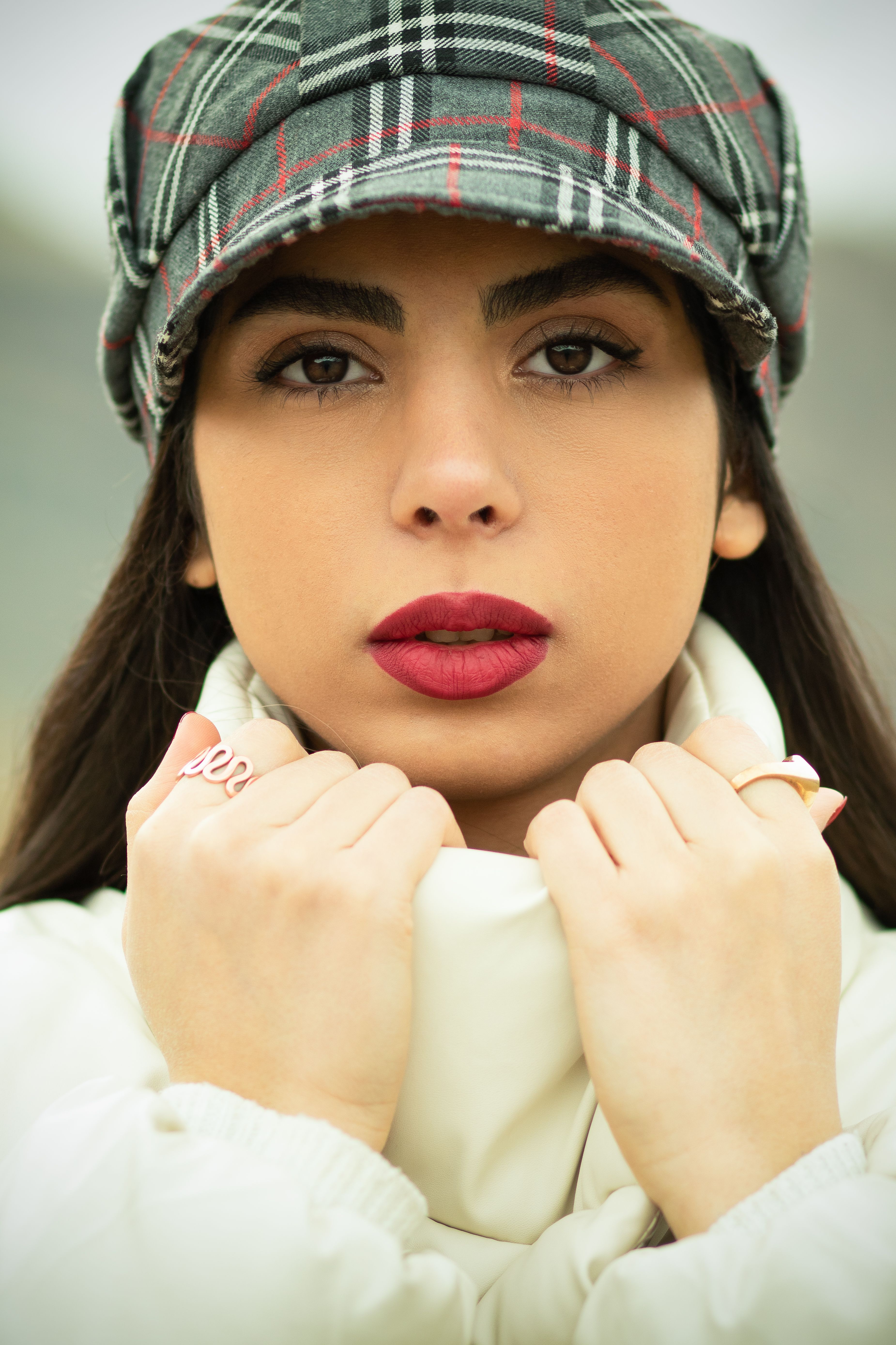 Elegant portrait of a woman in a newsboy hat, with red lips and beautiful eyes.