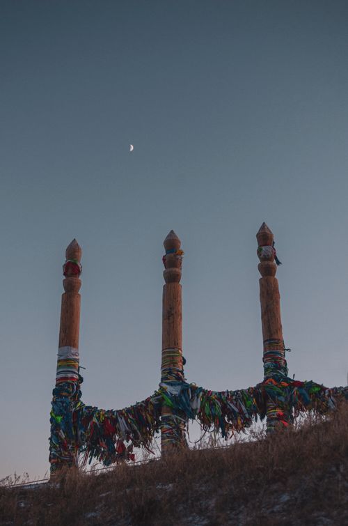 Free Traditional wooden poles with colorful cloths against a twilight sky and moon. Stock Photo