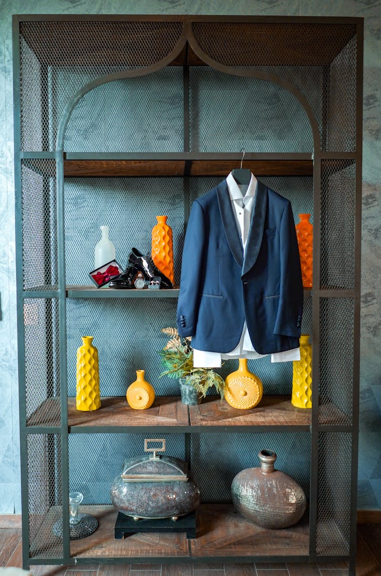 Arrangement Of Various Vases On Vintage Shelves And Blue Jacket Hanging