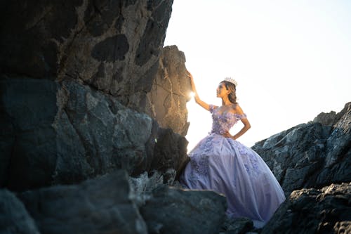 Woman Wearing Beautiful Gown Posing near the Black Rock Formation 