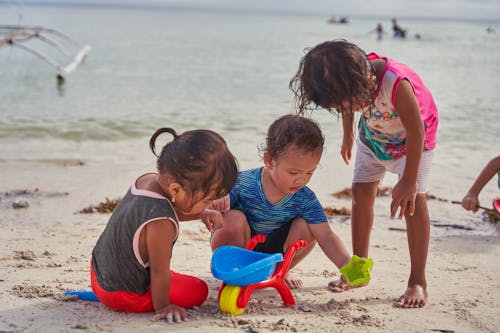 Free Children Playing on Beach Sand Stock Photo