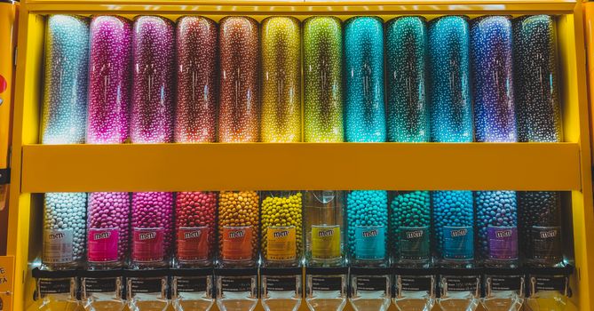 A vibrant arrangement of colorful candy dispensers filled with sweets in a shop.