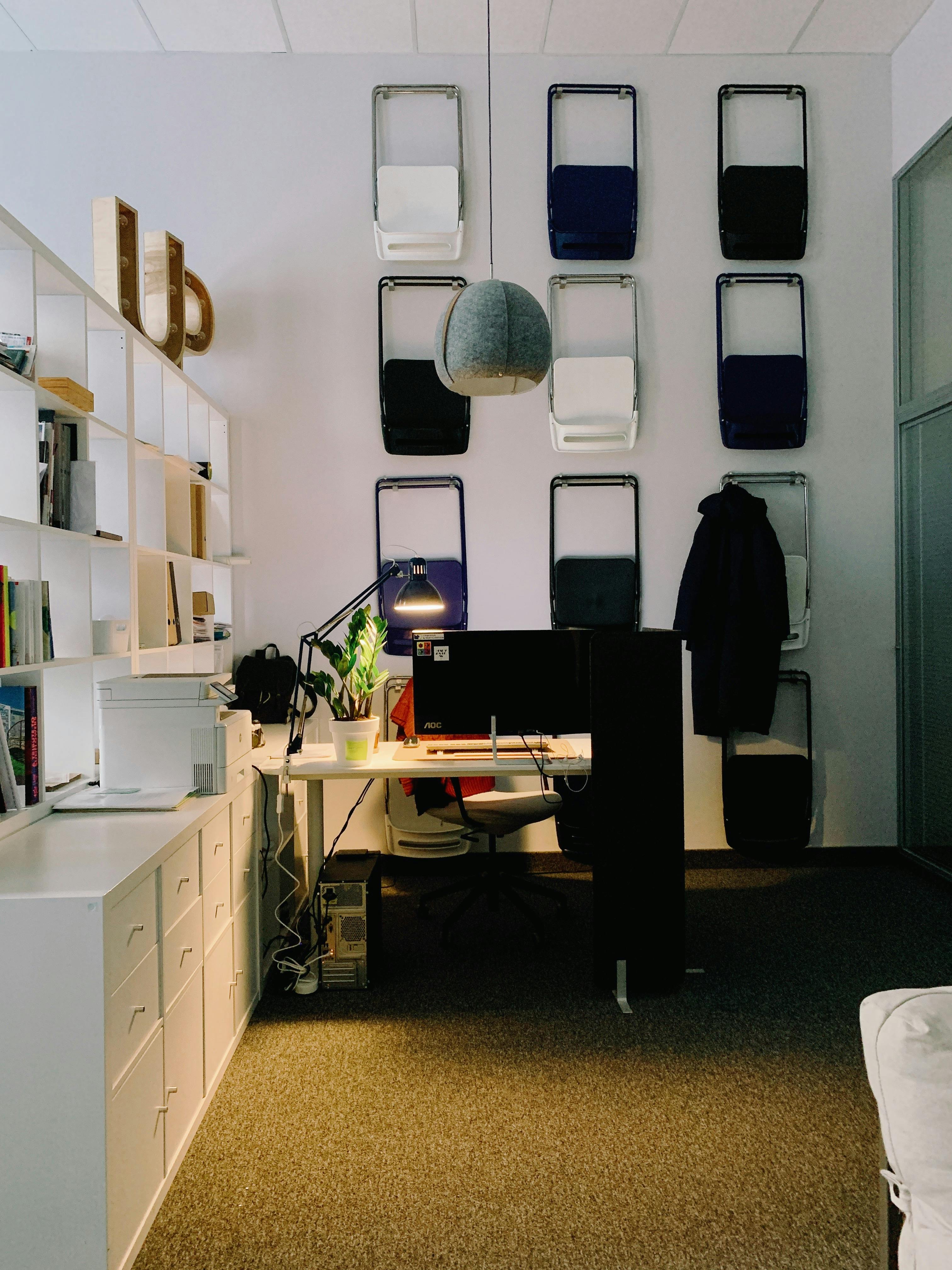 Contemporary office setup with unique wall art and stylish desk features.