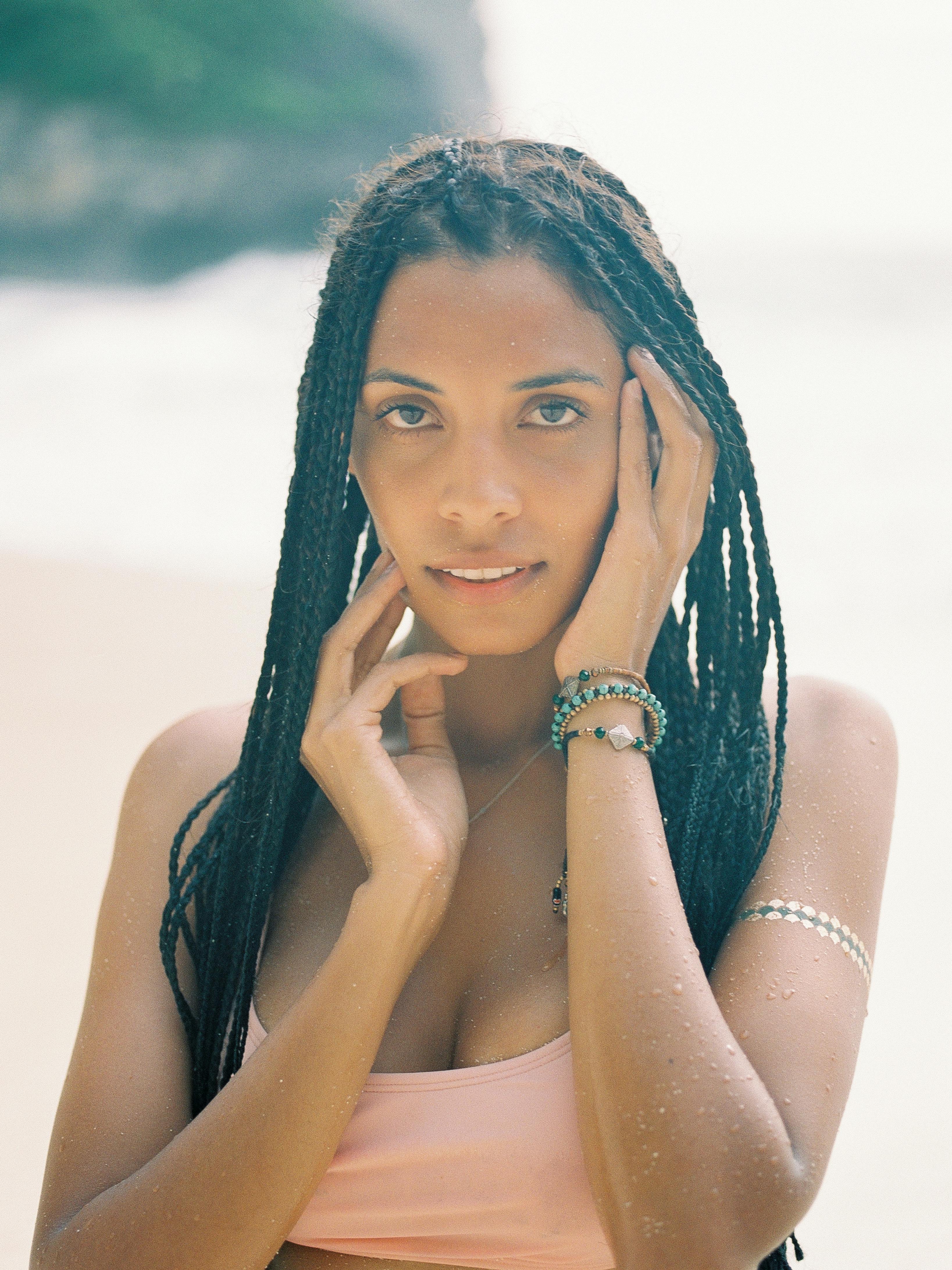 阳光明媚的海滩上一位扎着辫子的女人的肖像，散发着平静与美丽