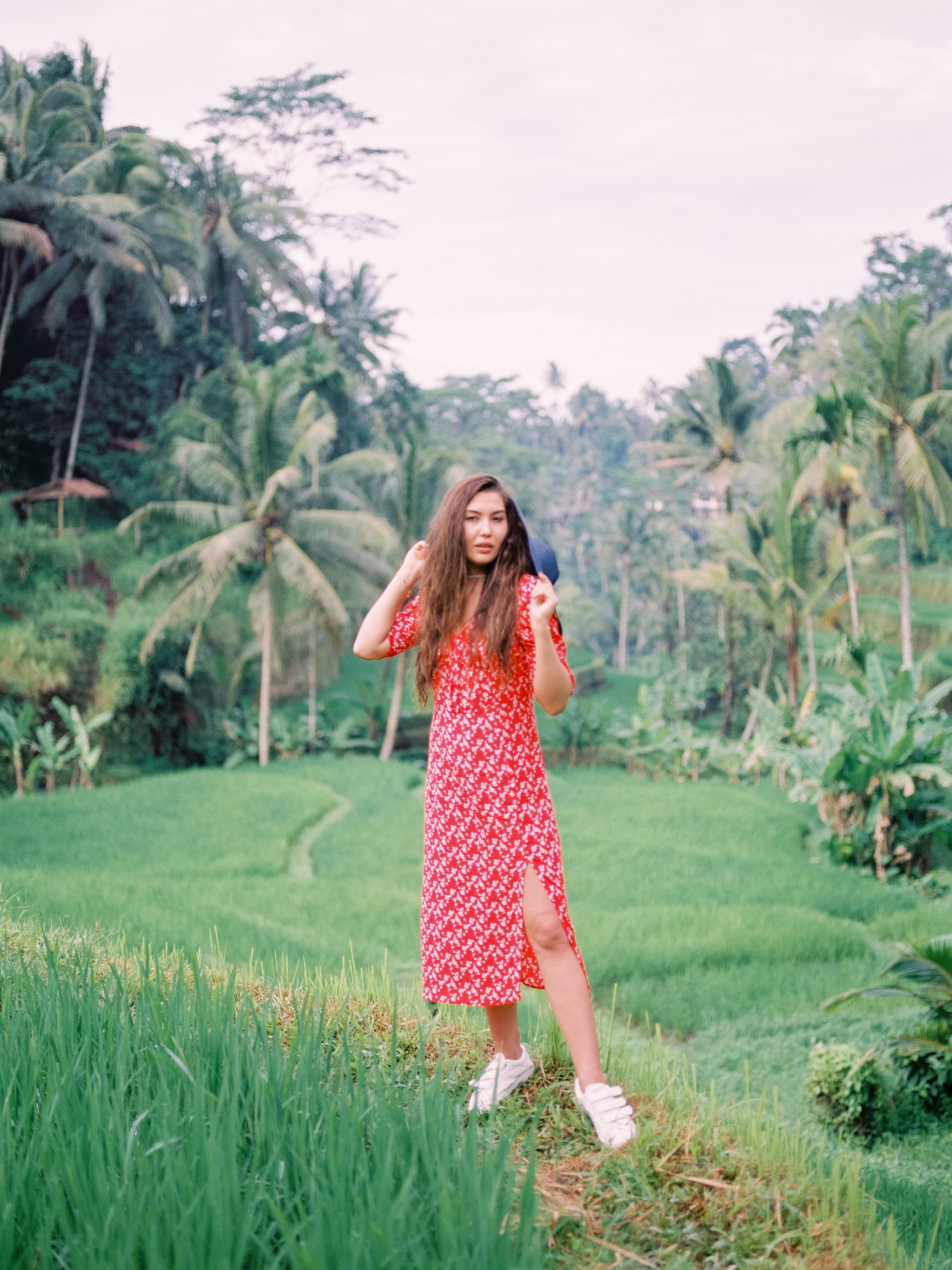 A Woman in Red and White Polka Dot Dress Standing on Green Grass Field ...