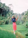 Woman Walking Through Tropical Forest Waving Hands in Air