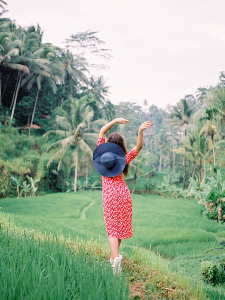 Woman Walking Through Tropical Forest Waving Hands In Air