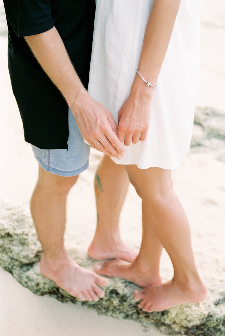 Legs And Hands Of Unrecognizable Heterosexual Couple Standing Face To Face On Beach