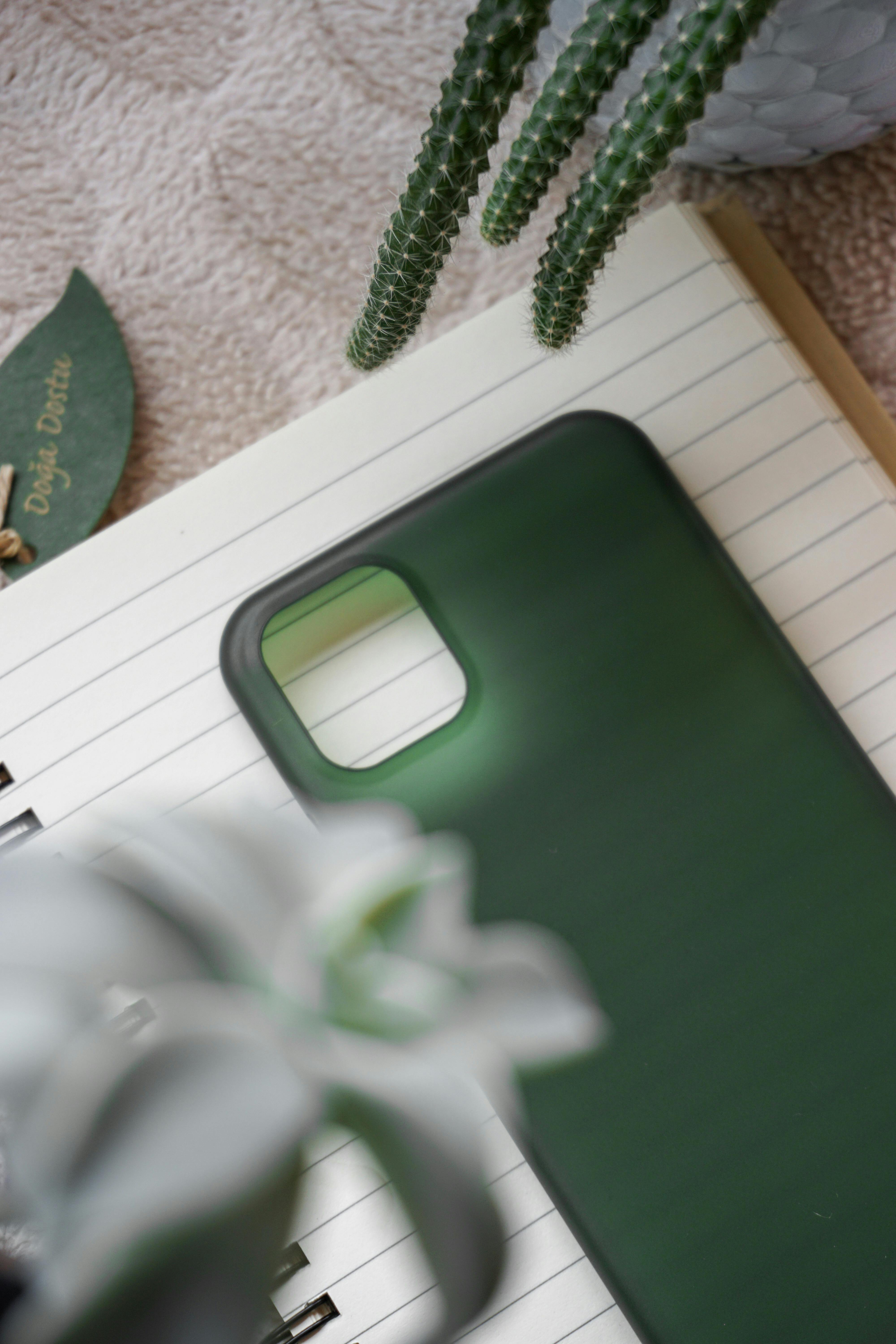 CloseUp Photo of a Green Phone Case on a Notebook · Free Stock Photo